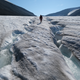 A hiker walks among winding channels carved by water on the surface of the melting Longyearbreen glacier during a summer heat wave on Svalbard archipelago on July 31, 2020.